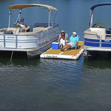 Island Hopper Patio Dock 15 Foot Inflatable Patio - The patio dock attached between small boats, with adults enjoying a sunbathe