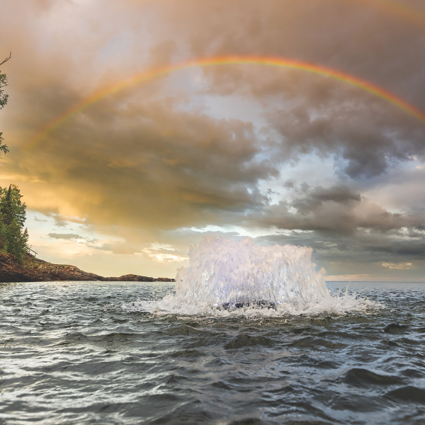 Surface Aerator in water with rainbow above it - Surface Aeration vs Bubble Aeration