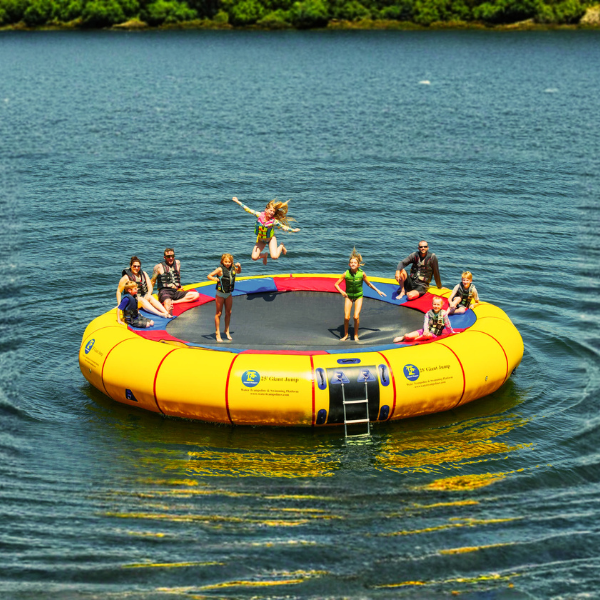 Yellow inflatable trampoline with people on a body of water - Water Trampoline vs Water Bouncer