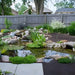 Aquascape 11′x16′ Medium Pond Kit - Backyard garden with a pond, rocks, and plants