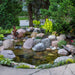 Aquascape 8'x11' Small Pond Kit - Small pond with rocks and plants in a garden setting
