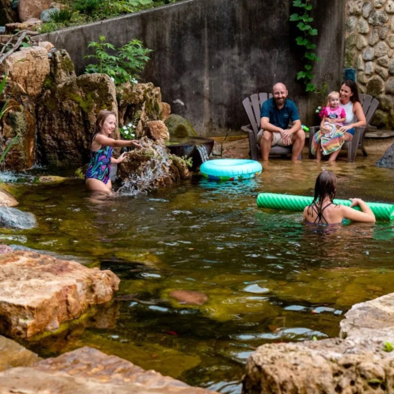 Family enjoying a natural swimming pond built with the Aquascape Recreational Pond Kit