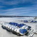 Frozen marina with boats covered for winter and open water areas maintained around docks using Kasco De-Icers