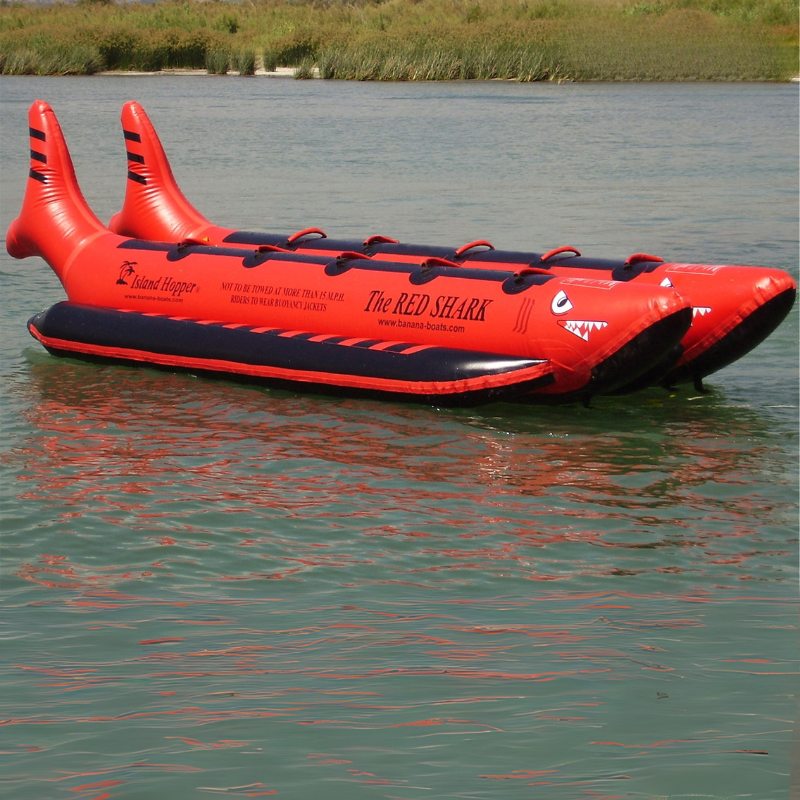 Island Hopper 10 Person Red Shark Banana Boat - Showing the side view of the banana boat on the water 