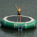 Island Hopper 13' Bounce and Splash Water Bouncer - Showing a girl raising her hands while on top of the green water bouncer