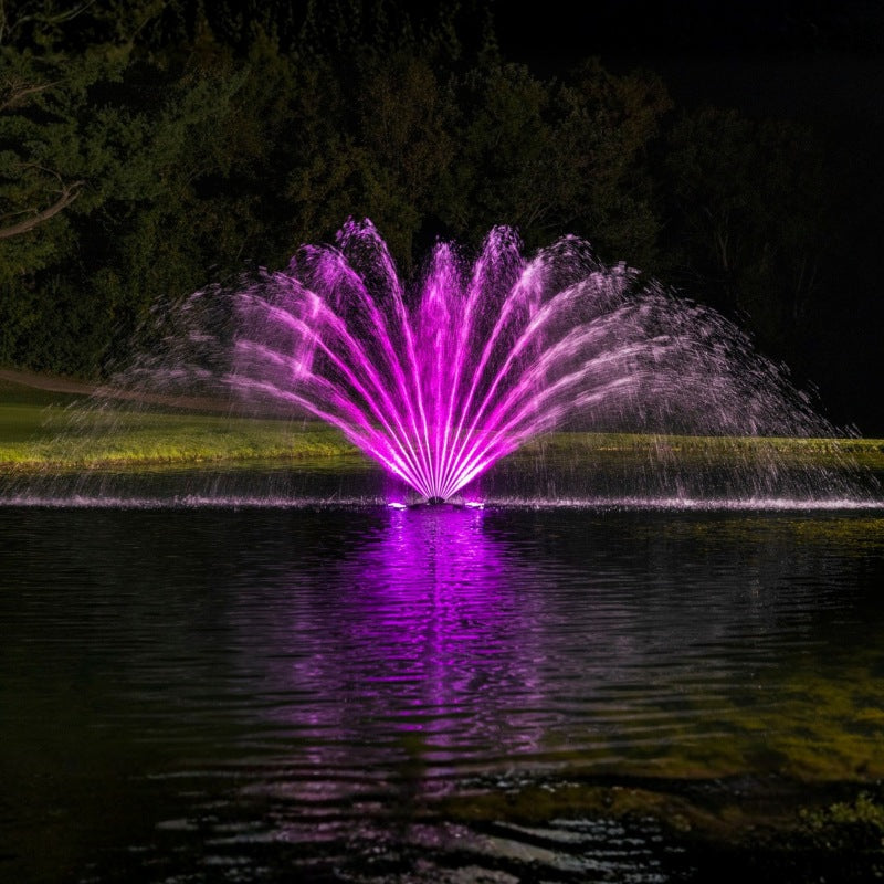 Kasco Fern Fountain with purple LED lighting display on pond at night