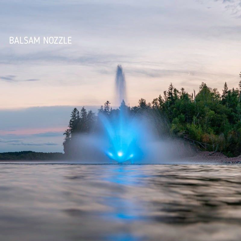 Kasco J Series Fountain with Balsam nozzle spray pattern illuminated by blue LED lighting at dusk in a wooded lake setting