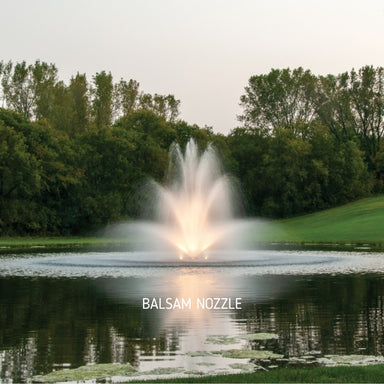 Kasco J Series Fountain with Balsam nozzle spray pattern illuminated by warm white LED lighting in a landscaped pond at night