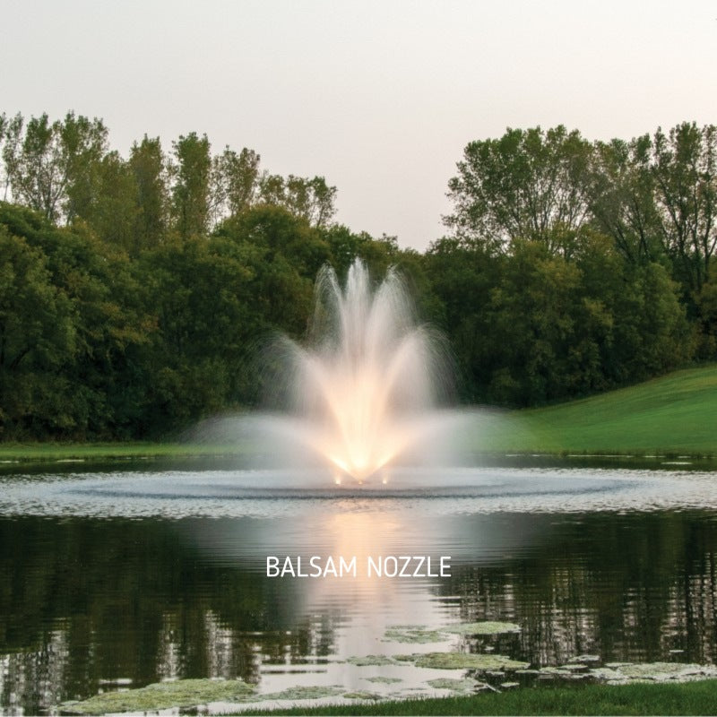 Kasco J Series Fountain with Balsam nozzle spray pattern illuminated by warm white LED lighting in a landscaped pond at night