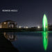Kasco J Series Fountain with Redwood Nozzle illuminated at night with green lighting in residential pond setting