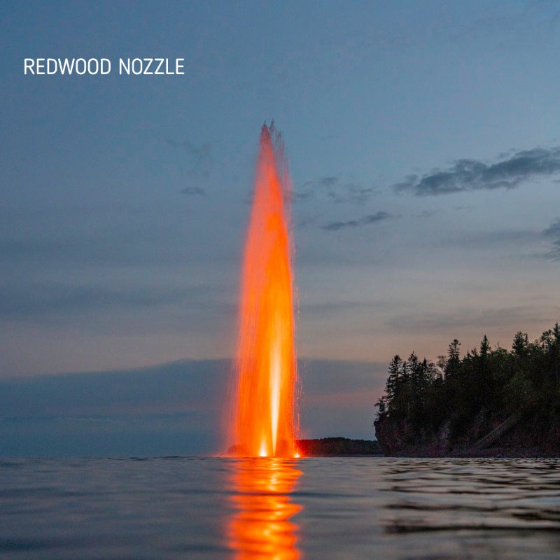 Kasco J Series Fountain with Redwood Nozzle illuminated at night with orange lighting on open lake