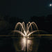 Kasco Magnolia Premium Fountain Nozzle - Fountain with illuminated water arches at night, surrounded by trees under a dark sky