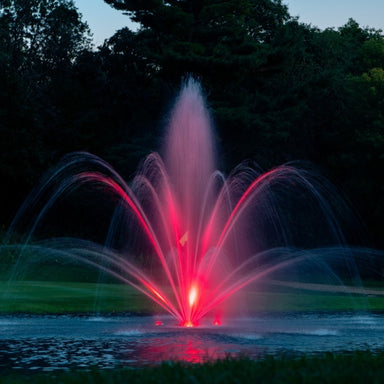 Kasco Mahogany Fountain Masterpiece Bundle illuminated at night with red lighting in golf course pond setting