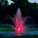Kasco Mahogany Fountain illuminated at night with red lighting in golf course pond setting