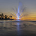 Kasco Mighty Oak Fountain illuminated with blue lighting at sunset on open lake low-angle view