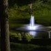 Kasco RGBW LED Lighting - W25 White LED Lighting System illuminating a pond fountain in a landscaped setting at night
