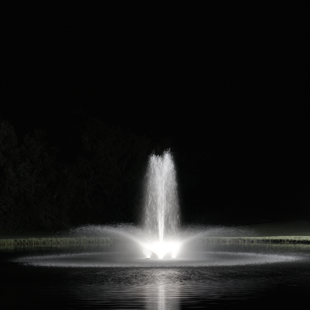 Kasco RGBW LED Lighting - W25 White LED Lighting System illuminating a vertical pond fountain with bright white light at night