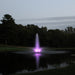 Kasco RGB LED Lighting illuminating a vertical pond fountain with purple light during dusk