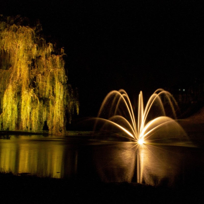 Kasco Stainless Steel LED Light Kit illuminating decorative pond fountain with warm white lighting at night