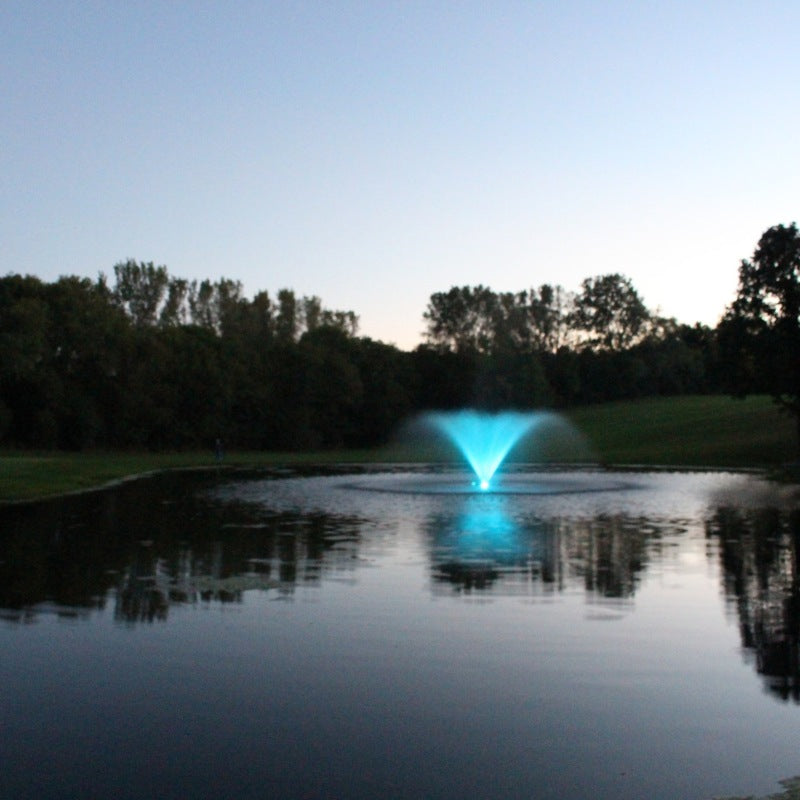 Kasco VFX aerating fountain with teal LED lighting in pond at dusk