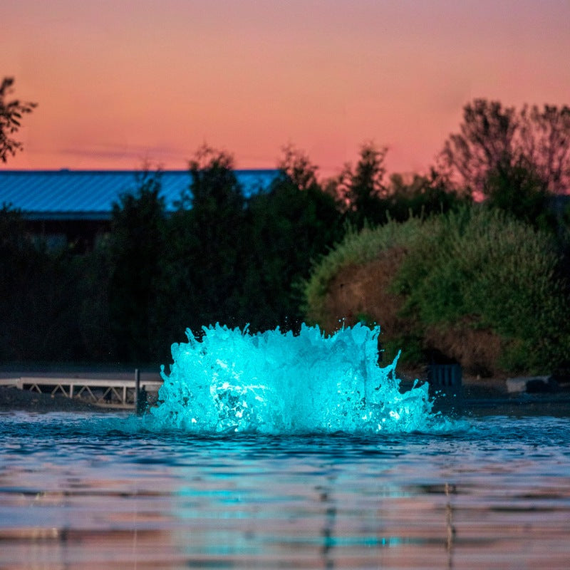 Kasco surface aerator with teal LED lighting in pond at dusk
