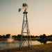 Outdoor Water Solutions Decorative Backyard Windmill 11.6 ft galvanized steel color displayed beside a pond at sunset