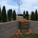 Outdoor Water Solutions Decorative Backyard Windmill galvanized steel, installed as a decorative feature in a landscaped outdoor area
