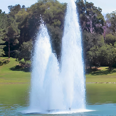 Vertex TriGeyser Floating Fountain Series On Water With Trees at the Background