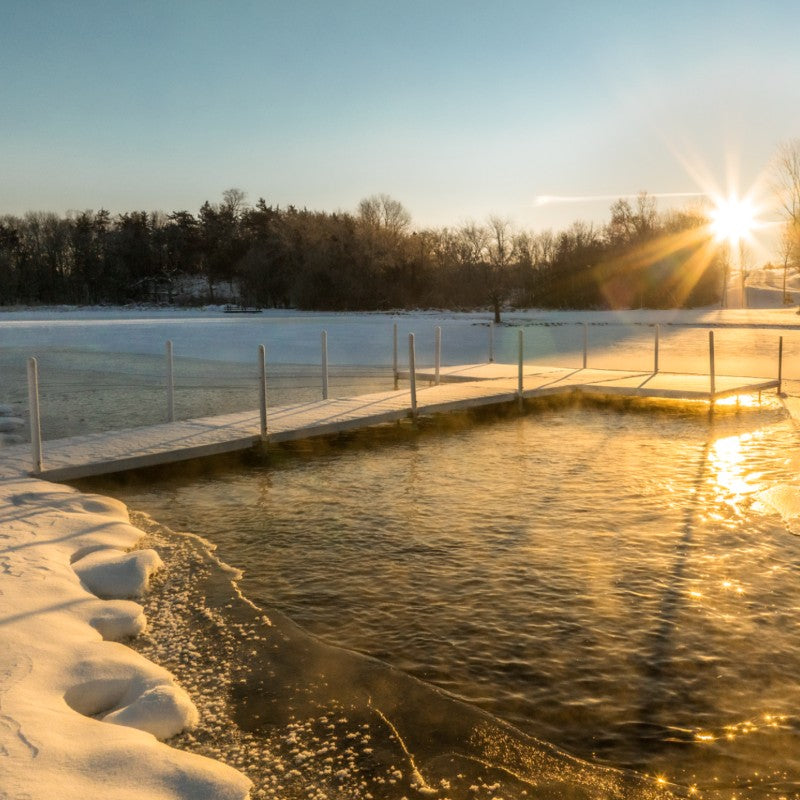 Winter dock with open water area around pier at sunrise demonstrating ice prevention using Kasco De-Icer