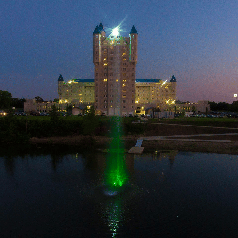 SCOTT AERATOR Jet Stream Fountain - On Water Display with Green Led Light at Night with Building at the Background